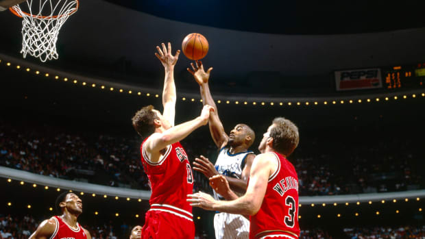Orlando Magic guard Dennis Scott (3) shoots over Chicago Bulls center Luc Longley (13), Bill Wennington (34) and Scottie Pippen (33) at the Orlando Arena.
